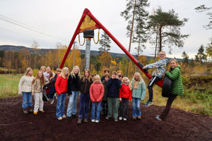 en gruppe mennesker poserer for et bilde foran en stor skulptur