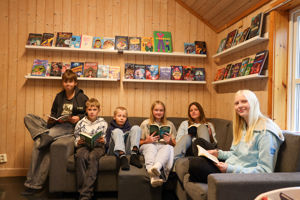 En gruppe mennesker som sitter i en sofa foran en bokhylle